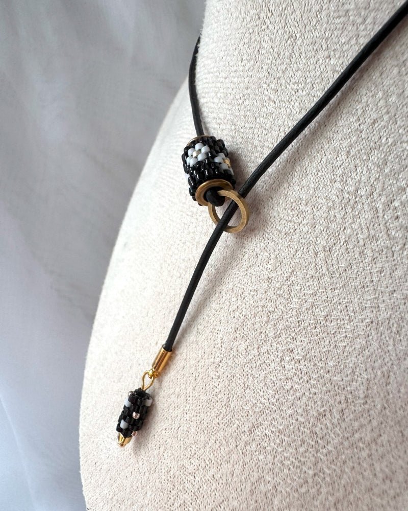 image Minimalist black lariat necklace with adjustable length, featuring floral beaded pendant and matching charm - Fleur Du Jour