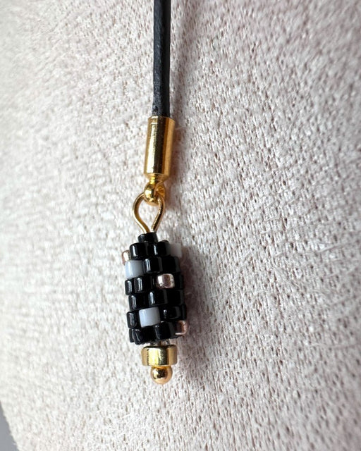 Minimalist black lariat necklace with adjustable length, featuring floral beaded pendant and matching charm - Fleur Du Jour