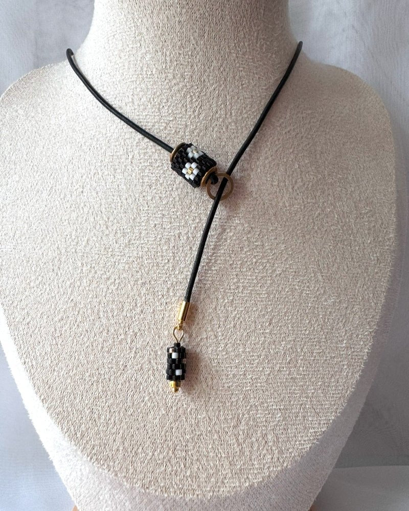 Minimalist black lariat necklace with adjustable length, featuring floral beaded pendant and matching charm - Fleur Du Jour