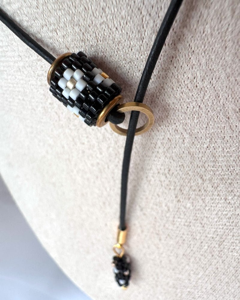 Minimalist black lariat necklace with adjustable length, featuring floral beaded pendant and matching charm - Fleur Du Jour