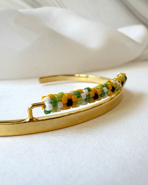 Open gold-plated sunflower cuff with a narrow linear Miyuki Delica bead strip in yellow, white, green and black - Fleur du Jour